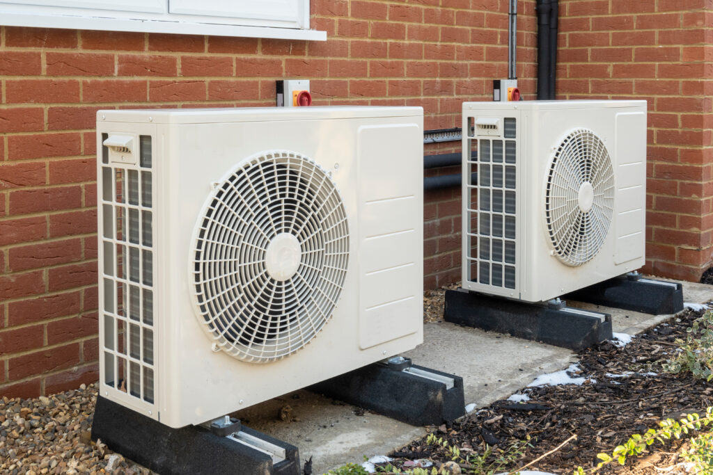 Image of two air source heat pumps installed on the exterior of a modern house